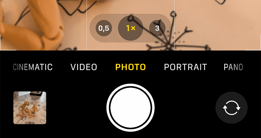 skærmbillede fra en iphone kamera app. Der er 3 tal i bunden af billedskærmen. Dem kan man trykke på for at skifte mellem linserne på iphonen. 